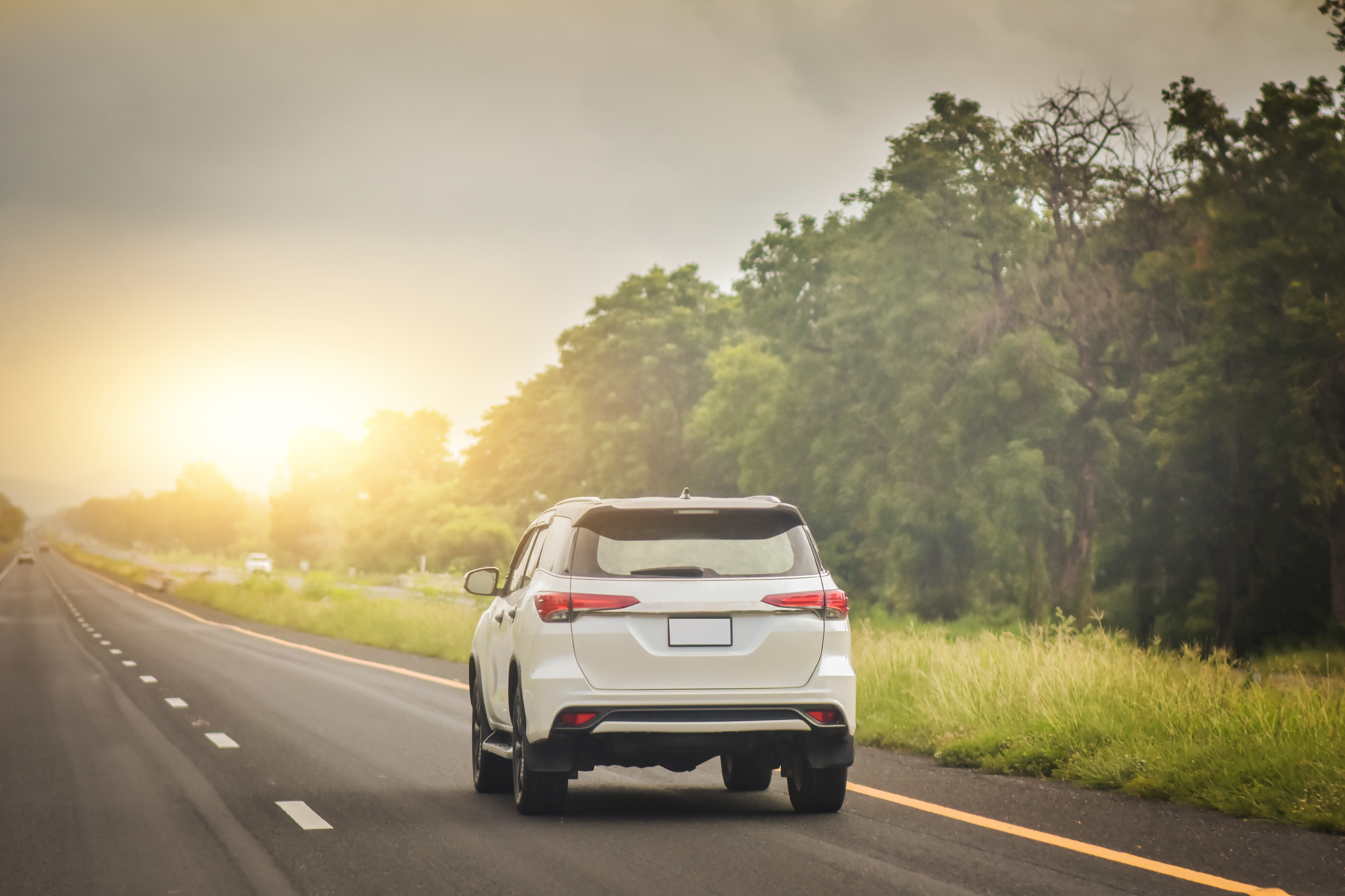 A relocated individual driving their car along the road which was successfully transported internationally with them